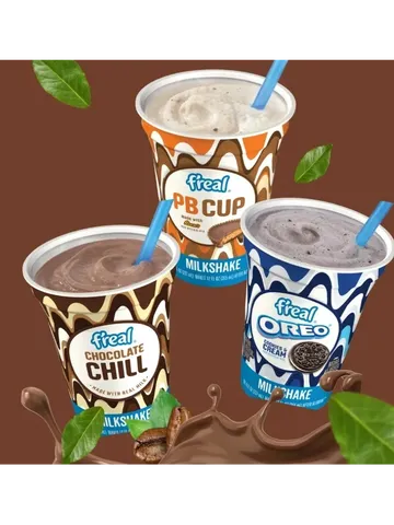 Three f'real milkshakes: Chocolate Chill, PB Cup, and Oreo, with floating chocolate and leaves in the background.