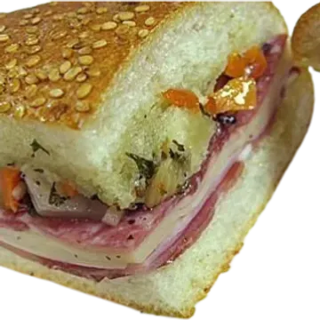 A close-up of a sandwich with layers of salami, cheese, and vegetables on a sesame seed bun.