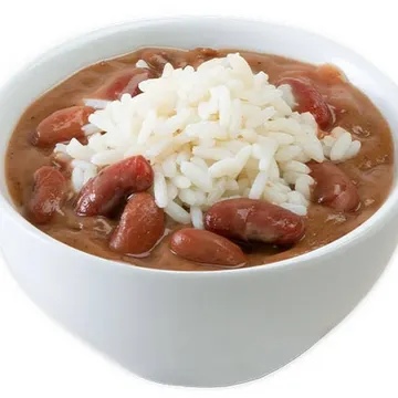 A bowl of red beans and rice with a small heap of white rice on top, served in a white bowl.