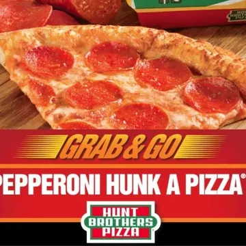 A slice of Hunt Brothers Pizza with pepperoni is displayed on a wooden surface. The text reads "Grab & Go: Pepperoni Hunk A Pizza.